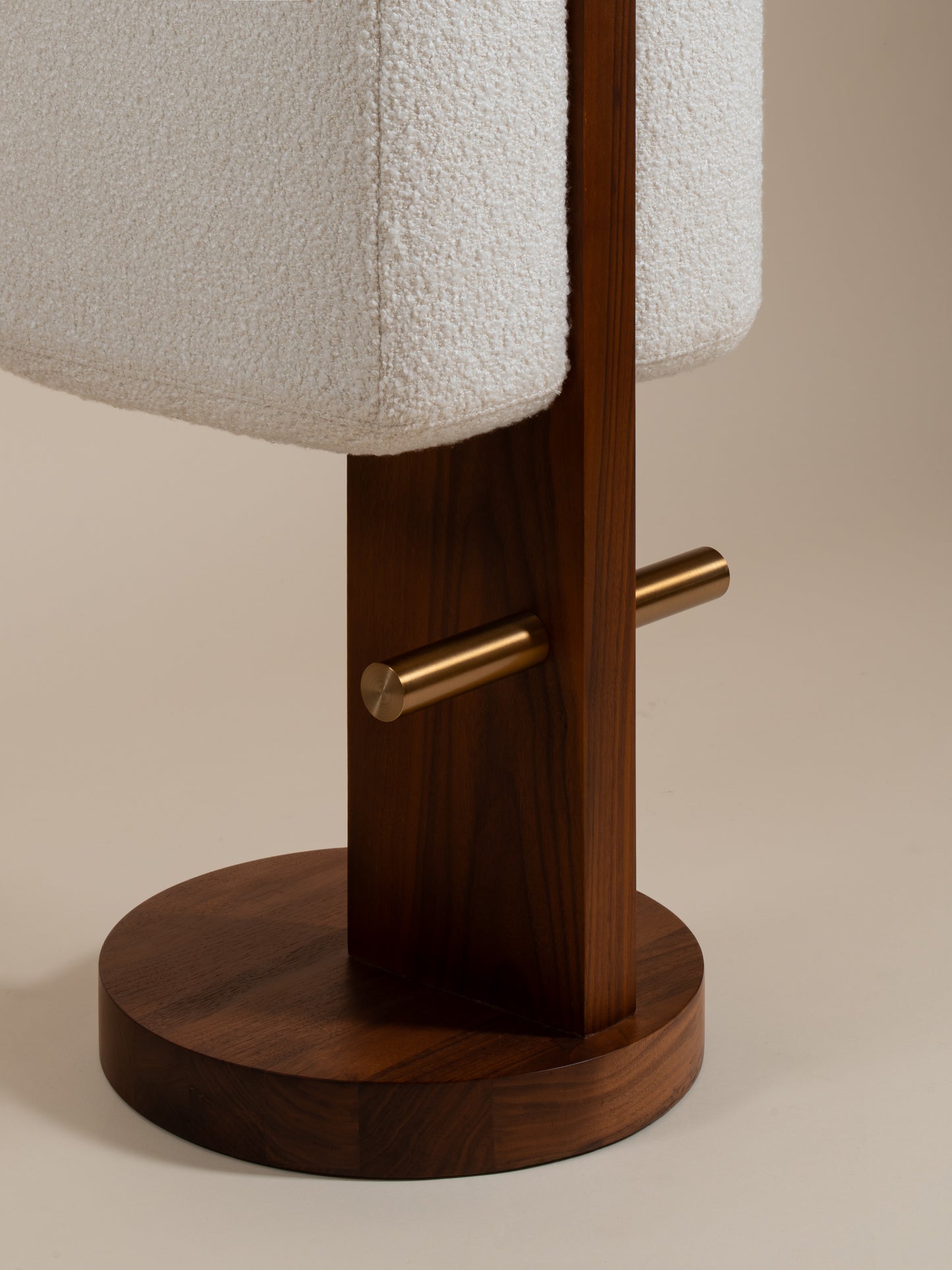 Close-up detail of walnut wood pedestal base and brass articulated footrest on Moment 2.5 Ice Cream Bar Stool