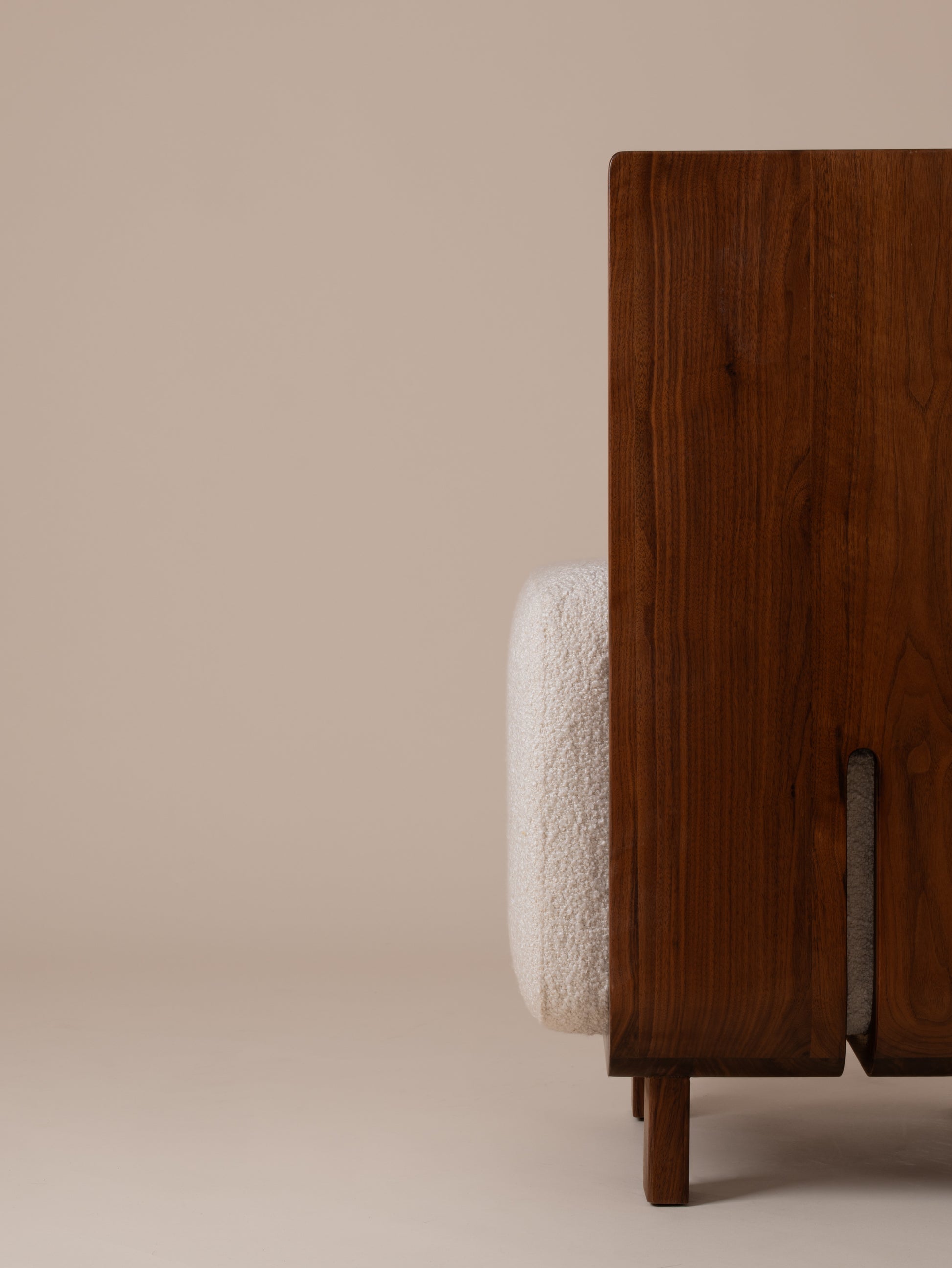 Detailed close-up of cream bouclé backrest and walnut frame structure on Moment 2.5 Onigi Chair