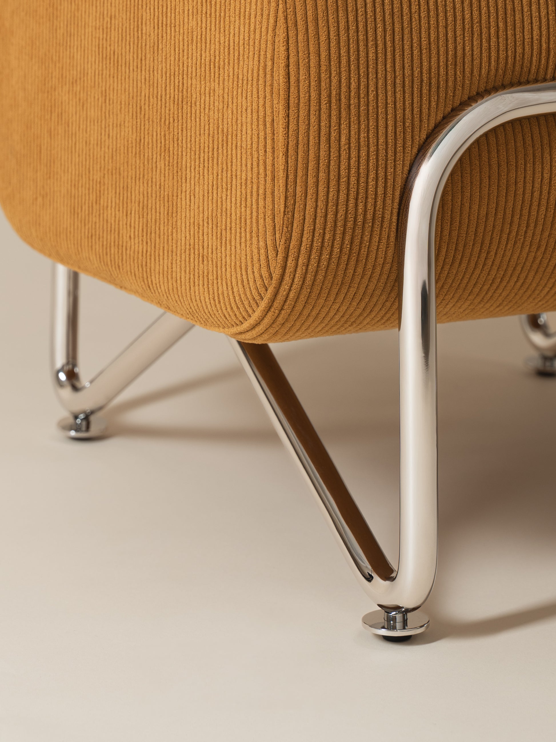 Close-up detail of warm mustard corduroy fabric, chrome-plated stainless steel frame and legs on Moment 2.5 Trolley Ottoman