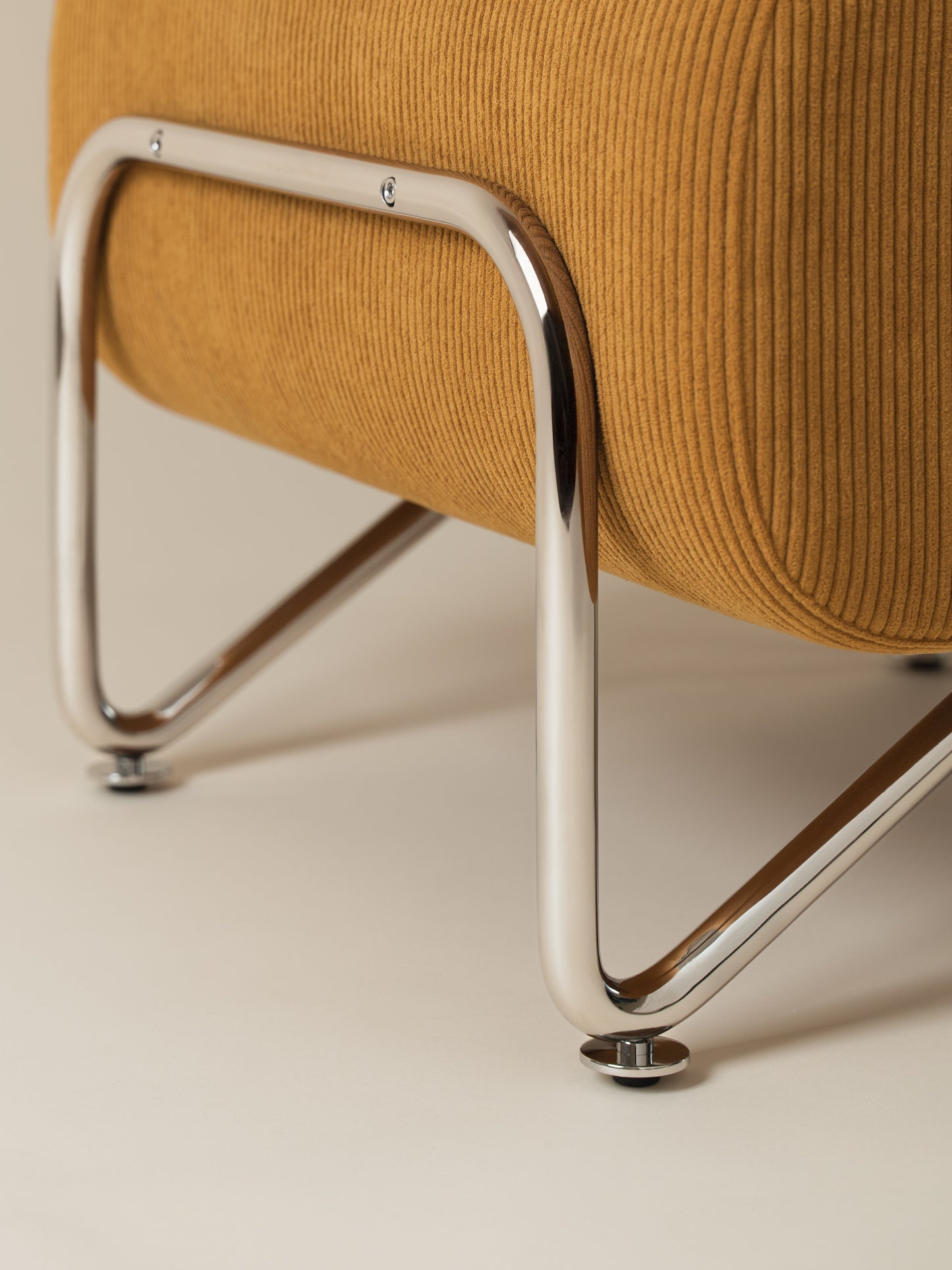 Detailed close-up of plush warm mustard corduroy upholstery and chrome-plated stainless steel frame and legs on Moment 2.5 Trolley Ottoman