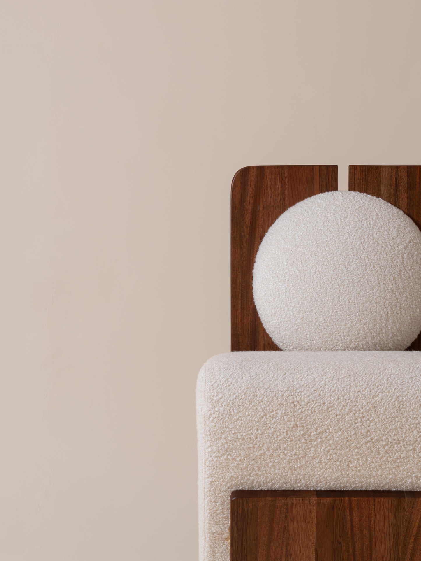 Detailed close-up of cream bouclé seat and walnut base on Moment 2.5 W Chair