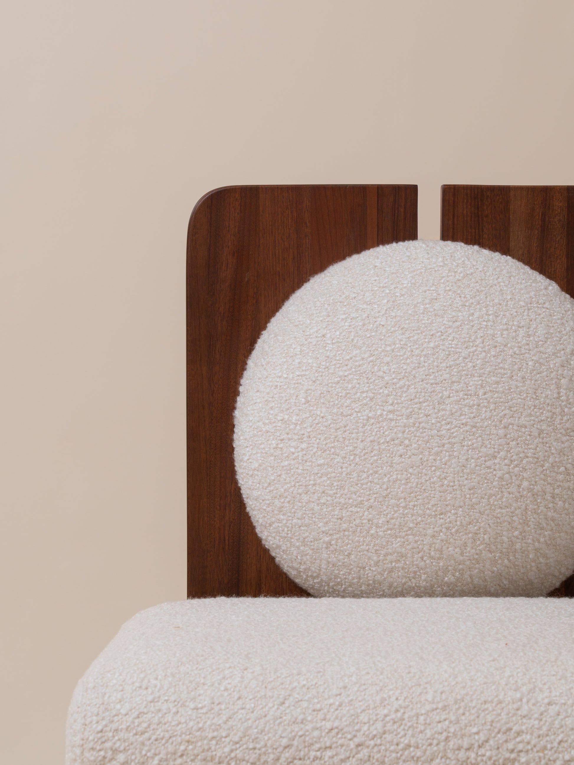 Close-up front view of plush cream bouclé seat on Moment 2.5 W Chair with walnut frame