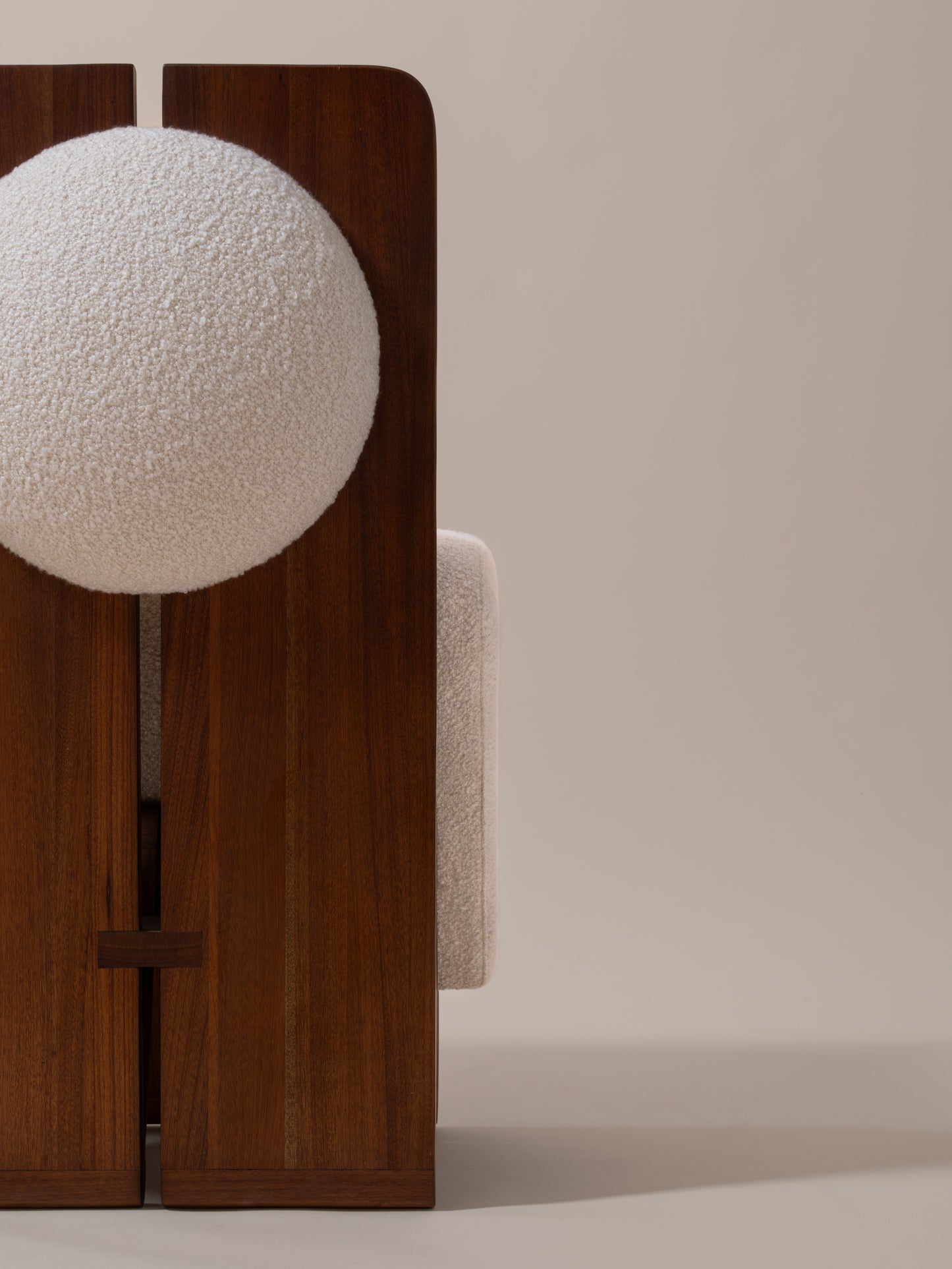 Close-up of cream bouclé upholstery and walnut wood backrest on Moment 2.5 W Chair